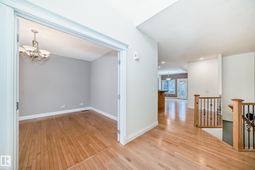 Hall with an upstairs landing, hanging lights, and light wood-style flooring - 1605 Haswell Court, Edmonton, AB - Indoor Photo Showing Other Room