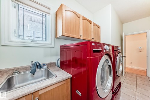 Laundry room with washer and clothes dryer, light tile patterned floors, and cabinet space - 1605 Haswell Court, Edmonton, AB - Indoor Photo Showing Laundry Room
