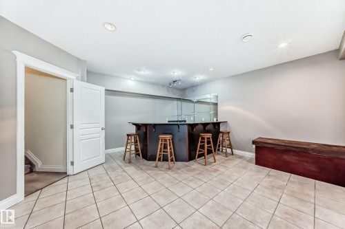 Indoor wet bar with dark countertops, light tile patterned floors, and recessed lighting - 1605 Haswell Court, Edmonton, AB - Indoor Photo Showing Other Room