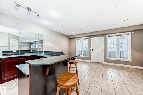 Kitchen with a breakfast bar, light tile patterned floors, bold wood finish cabinets, and recessed lighting - 1605 Haswell Court, Edmonton, AB - Indoor