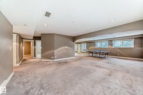 Empty room with arched walkways, light colored carpet, and recessed lighting - 1605 Haswell Court, Edmonton, AB - Indoor Photo Showing Other Room