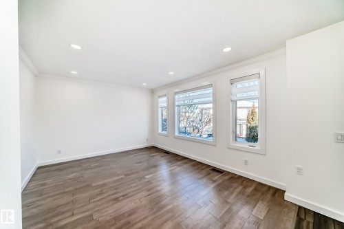 Empty room featuring dark wood-style floors, crown molding, and recessed lighting - 4008 37 Avenue, Edmonton, AB - Indoor Photo Showing Other Room