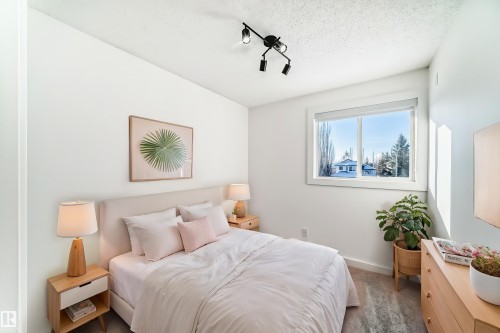 Carpeted bedroom with rail lighting and a textured ceiling - 4008 37 Avenue, Edmonton, AB - Indoor Photo Showing Bedroom