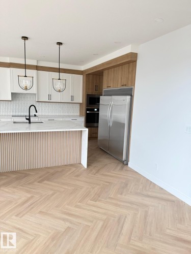 Contemporary kitchen featuring light wood-finish herringbone flooring and white walls - 53 Lilac Bay, Spruce Grove, AB - Indoor Photo Showing Kitchen