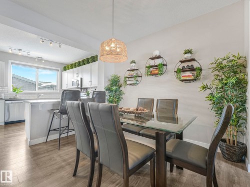 Open-concept dining area with light floors and a woven pendant light fixture - 725 36 Street, Edmonton, AB - Indoor Photo Showing Dining Room