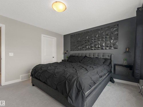 Bedroom featuring light gray walls, a gray textured accent wall, and a light gray carpet - 725 36 Street, Edmonton, AB - Indoor Photo Showing Bedroom