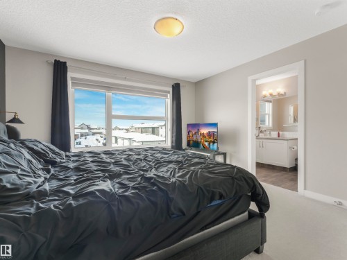 The property features a spacious room with light-colored walls and carpeted flooring - 725 36 Street, Edmonton, AB - Indoor Photo Showing Bedroom