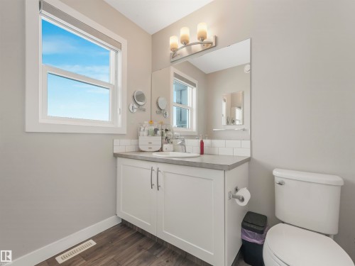 Bathroom featuring a single vanity with a white cabinet, a sink with a chrome faucet, and a toilet - 725 36 Street, Edmonton, AB - Indoor Photo Showing Bathroom