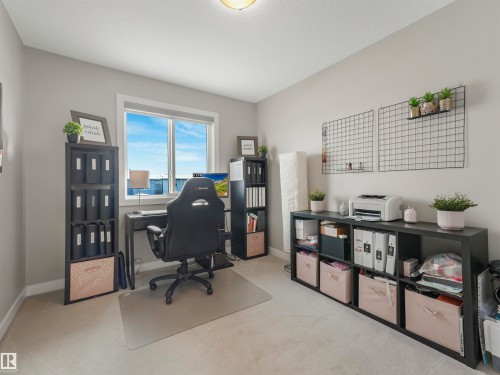 This well-lit room features a large window, light-colored carpeting, and neutral walls - 725 36 Street, Edmonton, AB - Indoor Photo Showing Other Room