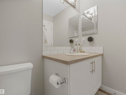Bathroom featuring a vanity with a countertop, an integrated sink, and white subway tile backsplash - 725 36 Street, Edmonton, AB - Indoor Photo Showing Bathroom