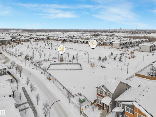 Aerial view of the surrounding neighbourhood, featuring a park with open spaces, bare trees, and visible residential properties - 725 36 Street, Edmonton, AB - Outdoor With View