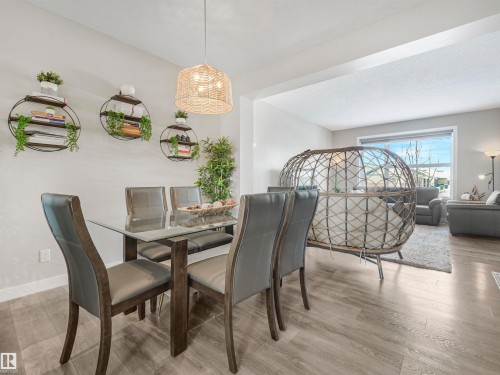The property features an open-concept living area with light wood-look flooring and light-colored walls - 725 36 Street, Edmonton, AB - Indoor Photo Showing Dining Room