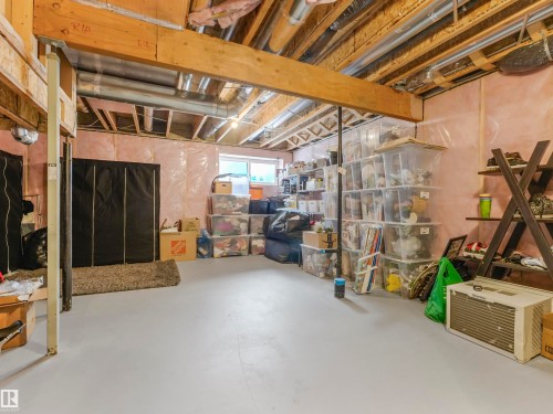 The unfinished basement features exposed wooden ceiling beams and a window - 725 36 Street, Edmonton, AB - Indoor Photo Showing Basement