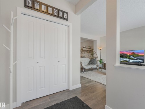 Entryway featuring light wood-style flooring and white bi-fold doors - 725 36 Street, Edmonton, AB - Indoor Photo Showing Other Room