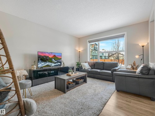 Living area featuring light-colored walls, a large window, and light-toned flooring - 725 36 Street, Edmonton, AB - Indoor Photo Showing Living Room