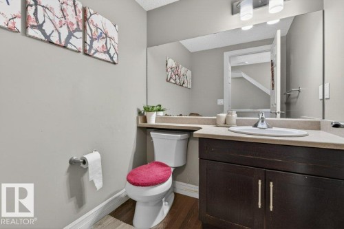 Bathroom vanity featuring a dark wood-finish cabinet with silver-tone hardware, an integrated sink, and a light-toned countertop - 40 14621 121 Street, Edmonton, AB - Indoor Photo Showing Bathroom