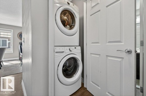 Stackable laundry appliances integrated within a dedicated utility area - 40 14621 121 Street, Edmonton, AB - Indoor Photo Showing Laundry Room