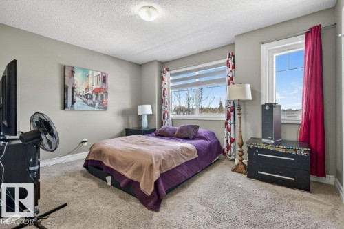 Carpeted bedroom with a flat white ceiling, neutral gray wall paint, and white trim - 40 14621 121 Street, Edmonton, AB - Indoor Photo Showing Bedroom
