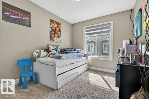 Carpeted room featuring neutral wall tones and a window with blinds - 40 14621 121 Street, Edmonton, AB - Indoor Photo Showing Bedroom
