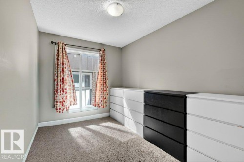 Window with white trim and a black curtain rod, light gray walls, and carpeted flooring - 40 14621 121 Street, Edmonton, AB - Indoor