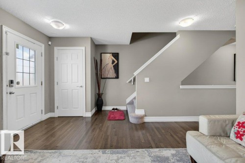 Entryway featuring wood-finish flooring, white baseboards, and a paneled white door with a multi-pane window - 40 14621 121 Street, Edmonton, AB - Indoor Photo Showing Other Room