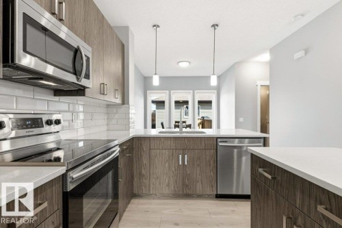 Modern kitchen featuring stainless steel appliances, wood-finish cabinetry, and white subway tile backsplash - 17451 77 Street, Edmonton, AB - Indoor Photo Showing Kitchen With Upgraded Kitchen