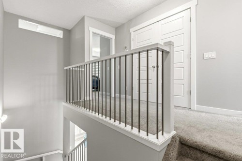 Upper-level landing featuring a contemporary white railing with dark metal spindles - 17451 77 Street, Edmonton, AB - Indoor Photo Showing Other Room