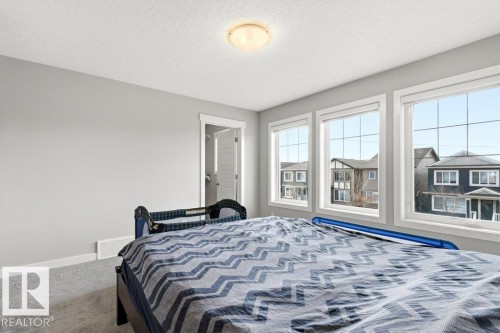 Room featuring three large windows, light gray wall paint, white trim, carpet flooring, and a flush mount ceiling light fixture - 17451 77 Street, Edmonton, AB - Indoor Photo Showing Bedroom
