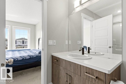 Double vanity with dual undermount sinks, matte black faucets, and a light wood-finish cabinet - 17451 77 Street, Edmonton, AB - Indoor Photo Showing Bathroom
