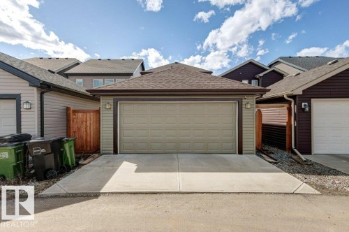 Detached rear garage with a concrete driveway, two exterior wall sconces, and a brown shingle roof - 17451 77 Street, Edmonton, AB - Outdoor With Exterior