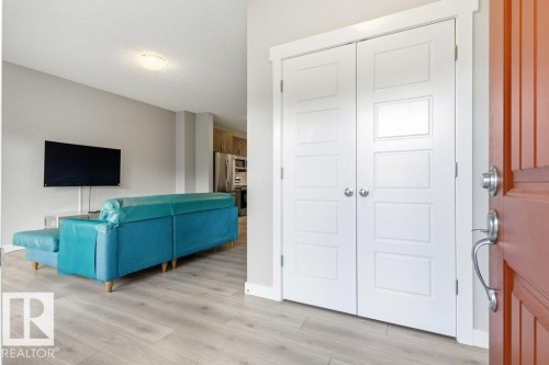 Entryway featuring a solid wood panel door, bi-fold closet doors, and wood-finish flooring extending into the living area - 17451 77 Street, Edmonton, AB - Indoor Photo Showing Other Room