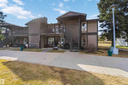 Multi-level building with brown siding and trim, featuring multiple entryways and exterior staircases - 5740 172 Street, Edmonton, AB - Outdoor