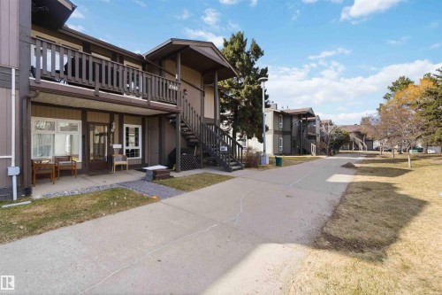 Brown-toned building exterior with a second-story balcony featuring wood railings - 5740 172 Street, Edmonton, AB - Outdoor