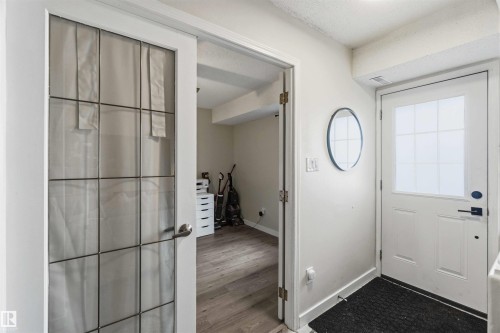 Entryway featuring a solid white door with a window insert, dark hardware, and light wood-finish flooring - 5740 172 Street, Edmonton, AB - Indoor Photo Showing Other Room