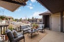 Expansive outdoor patio featuring a neutral concrete surface, string lighting, and dark wood-finish railing - 5740 172 Street, Edmonton, AB  - Outdoor With Exterior 