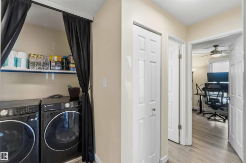 Dedicated laundry area featuring a built-in shelf and dark-toned appliances - 5740 172 Street, Edmonton, AB - Indoor Photo Showing Laundry Room