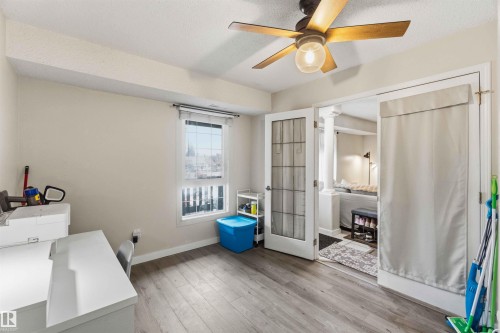 Room featuring wood-finish flooring, a window with blinds, and a ceiling fan with integrated lighting - 5740 172 Street, Edmonton, AB - Indoor