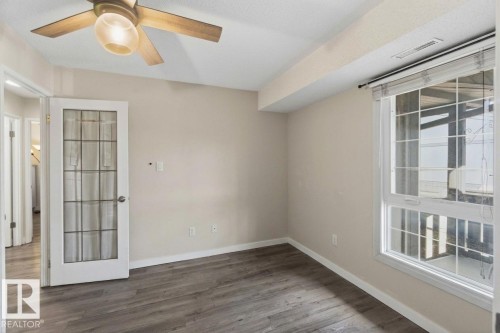 Room with wood-finish flooring, a ceiling fan, and a large window with blinds - 5740 172 Street, Edmonton, AB - Indoor Photo Showing Other Room