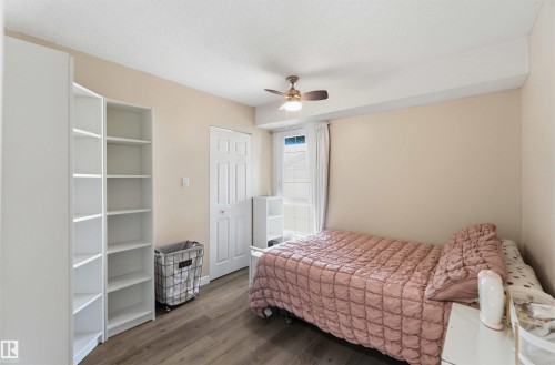 Room featuring wood-finish flooring, a ceiling fan, and an exterior window with vertical blinds - 5740 172 Street, Edmonton, AB - Indoor Photo Showing Bedroom