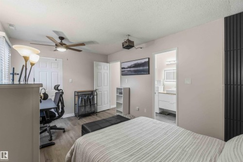 Bedroom featuring wood-finish flooring, a ceiling fan with integrated lighting, and direct access to a bathroom - 5740 172 Street, Edmonton, AB - Indoor Photo Showing Bedroom
