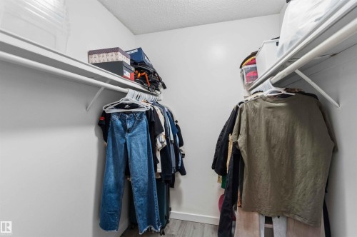 Walk-in closet featuring white walls, textured ceiling, and wood-finish flooring - 5740 172 Street, Edmonton, AB - Indoor With Storage