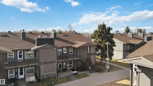 Multi-unit building exterior with brown siding, brown shingle roofing, multiple balconies, and exterior staircases - 5740 172 Street, Edmonton, AB - Outdoor