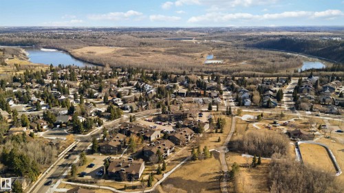 Expansive aerial perspective showcasing a residential area bordered by a winding river and extensive wooded terrain - 5740 172 Street, Edmonton, AB - Outdoor With View