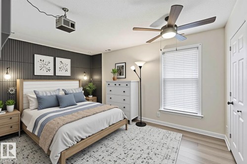 Bedroom featuring an accent wall with vertical paneling, light wood-finish flooring, a ceiling fan with integrated lighting, and a window with blinds - 5740 172 Street, Edmonton, AB - Indoor Photo Showing Bedroom
