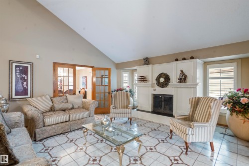 Living room featuring a vaulted ceiling and patterned tile flooring - 9831 158 Avenue, Edmonton, AB - Indoor Photo Showing Living Room With Fireplace