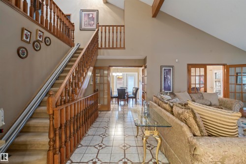 Grand entryway featuring a staircase with wood balusters, a built-in stair lift, and patterned tile flooring - 9831 158 Avenue, Edmonton, AB - Indoor Photo Showing Other Room