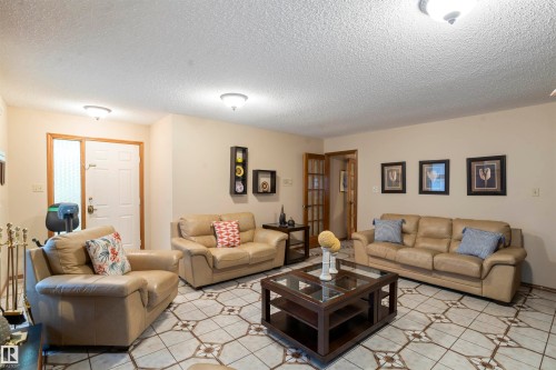 Living area featuring patterned tile flooring, light-toned wall paint, and multiple ceiling-mounted light fixtures - 9831 158 Avenue, Edmonton, AB - Indoor Photo Showing Living Room