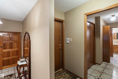 Foyer entry featuring a paneled wood door, patterned tile flooring, and neutral wall paint - 9831 158 Avenue, Edmonton, AB - Indoor Photo Showing Other Room