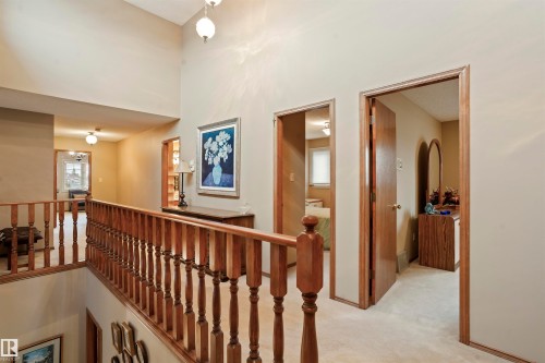 Upper-level landing featuring wood balusters, neutral wall paint, and plush carpeting - 9831 158 Avenue, Edmonton, AB - Indoor Photo Showing Other Room