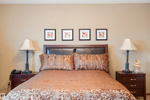Bed with dark wood headboard featuring a faux leather panel - 9831 158 Avenue, Edmonton, AB - Indoor Photo Showing Bedroom